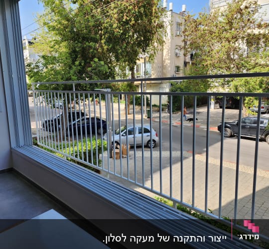 מעקה מתכת לבן במרפסת עם נוף לרחוב